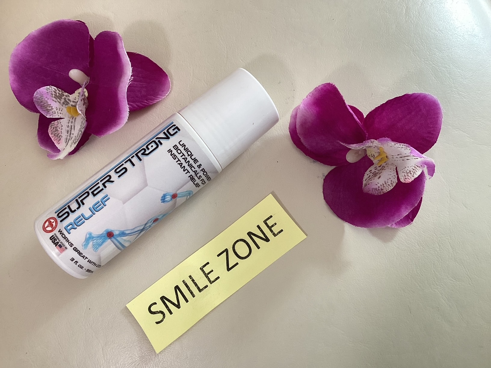 Super Strong Relief topical pain relief bottle with orchids